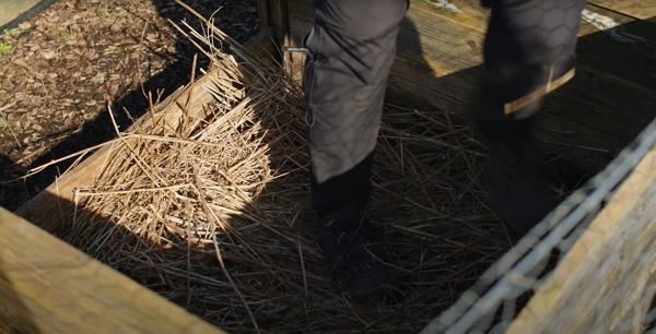 Huw applying the fibrous base layer in his compost bin