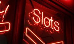 A red slots sign on the dark.