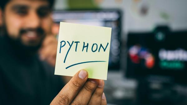 Someone holding a post-it with Python written on it