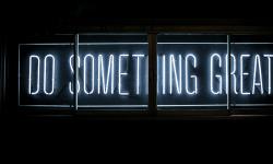 A "Do Something Great" sign in the dark