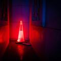 An illuminated red road work cone