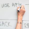 A woman writing ‘Use APIS’ on a white board.