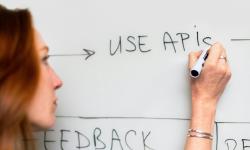 A woman writing ‘Use APIS’ on a white board.