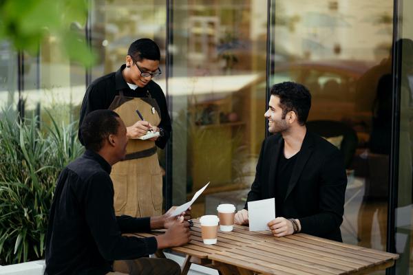 A waiter taking an order from two men