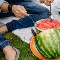 A man and a woman scooping into a watermelon