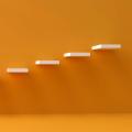 An orange wall with shelves at various level