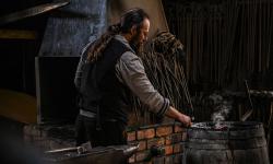 A skilled blacksmith working in his rustic workshop, crafting metal with traditional tools.