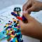 Children’s hands play with colorful toy blocks on a table inside a room in East Java, Indonesia.